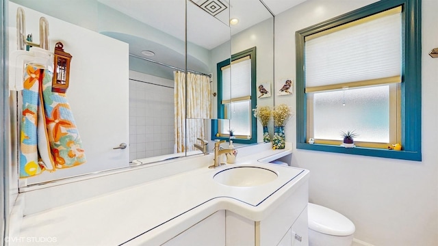 full bath with toilet, vanity, and curtained shower