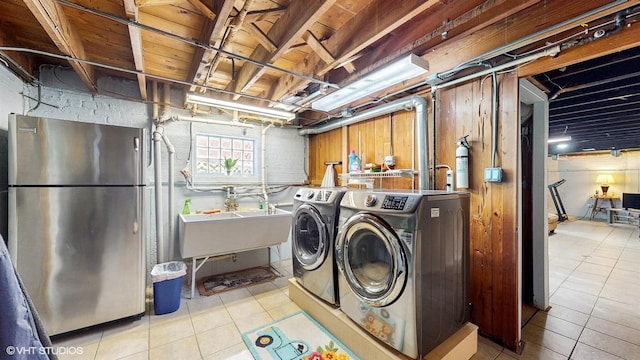 clothes washing area with washer and clothes dryer and tile patterned flooring