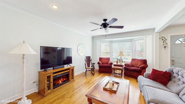 living room featuring healthy amount of natural light, light wood-style flooring, ceiling fan, baseboards, and recessed lighting