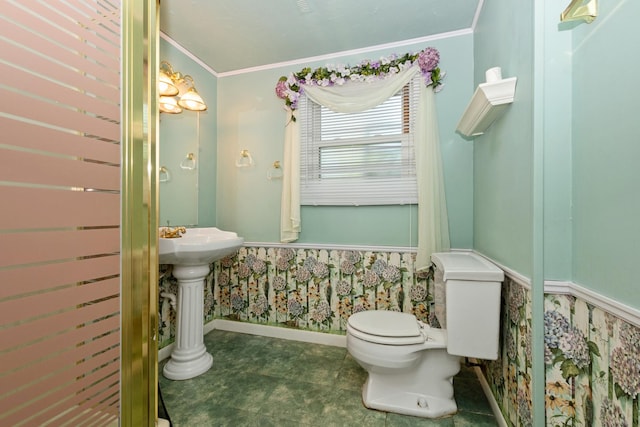 half bath featuring baseboards, crown molding, and toilet