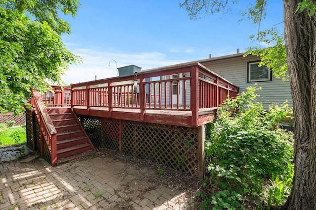 rear view of property with a deck, a patio area, and stairway