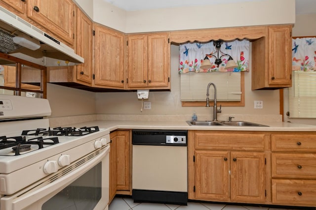 kitchen with white appliances, under cabinet range hood, a sink, light countertops, and light tile patterned floors
