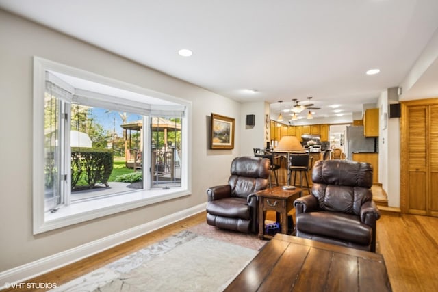 living room with light wood-style flooring, baseboards, and recessed lighting