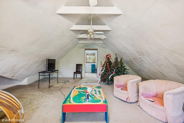 recreation room featuring carpet floors, vaulted ceiling, and a ceiling fan