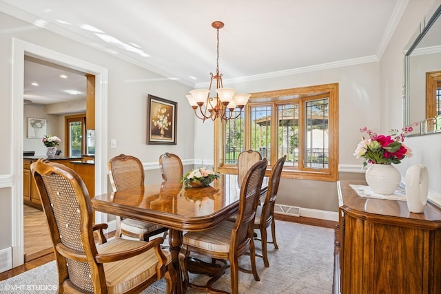 dining space with light wood-type flooring, ornamental molding, a chandelier, baseboards, and recessed lighting