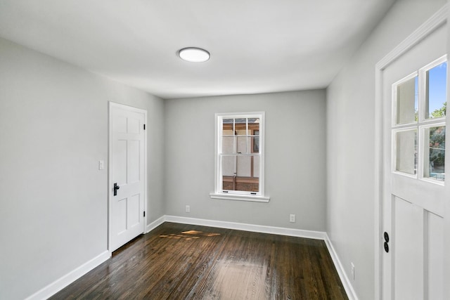 entryway with dark wood-type flooring and baseboards