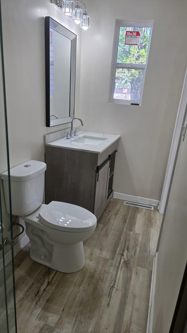 301 N W Ave, Kankakee, IL 60901 - bathroom with wood finished floors, toilet, vanity, and baseboards