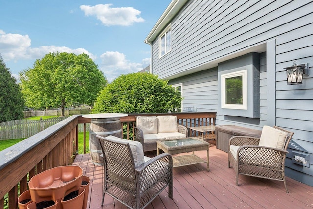 wooden terrace with an outdoor hangout area and fence