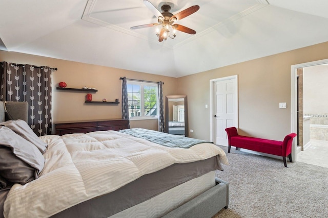 carpeted bedroom featuring a tray ceiling, lofted ceiling, ceiling fan, and ensuite bath