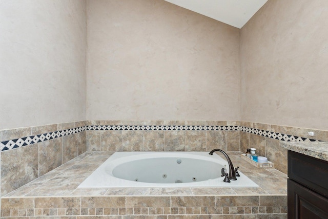 full bath featuring a jetted tub and vanity