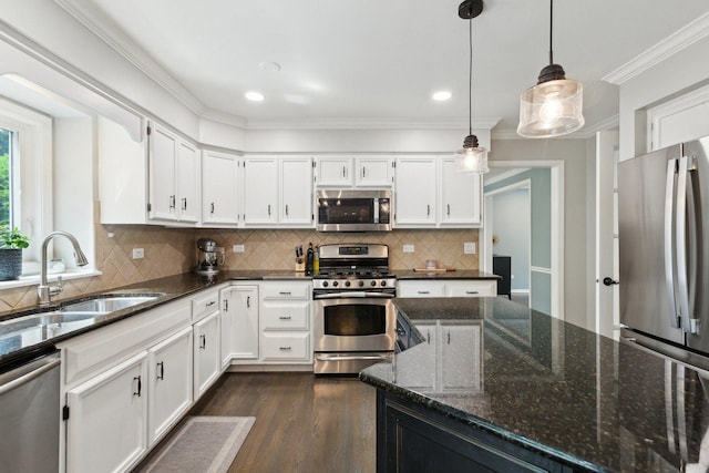 kitchen featuring stainless steel appliances, a sink, dark wood-type flooring, white cabinetry, and tasteful backsplash