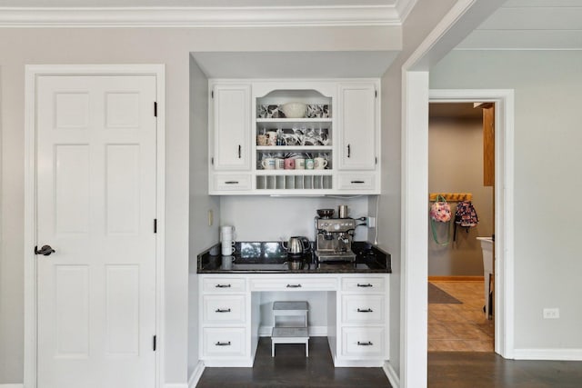 bar with baseboards, crown molding, built in study area, and dark wood-style flooring