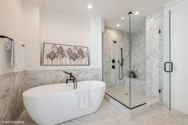 bathroom with tile walls, marble finish floor, ornamental molding, a freestanding tub, and a marble finish shower