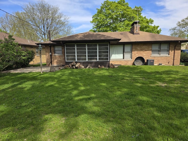 7330 N Kildare Ave, Lincolnwood, IL 60712 - back of property featuring brick siding, a yard, cooling unit, and a chimney