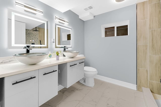 full bathroom featuring a sink, tiled shower, marble finish floor, and visible vents