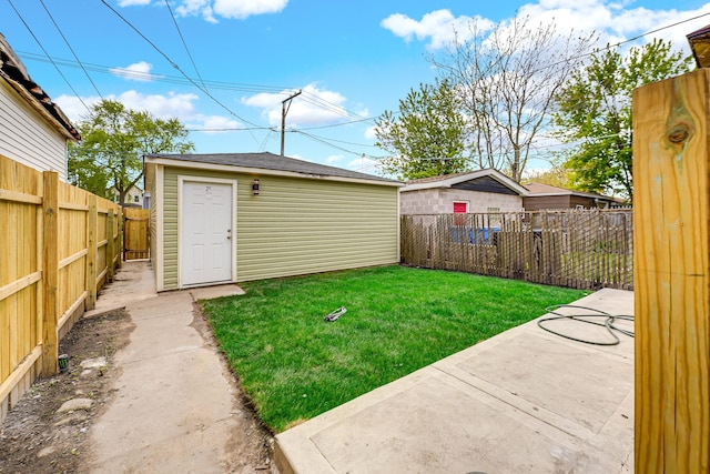 view of yard featuring an outbuilding, a patio area, and a fenced backyard