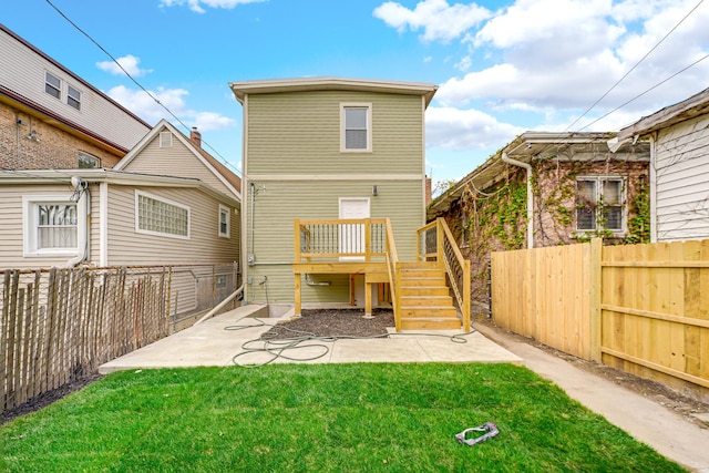 back of property with a fenced backyard, a deck, a patio, and a lawn