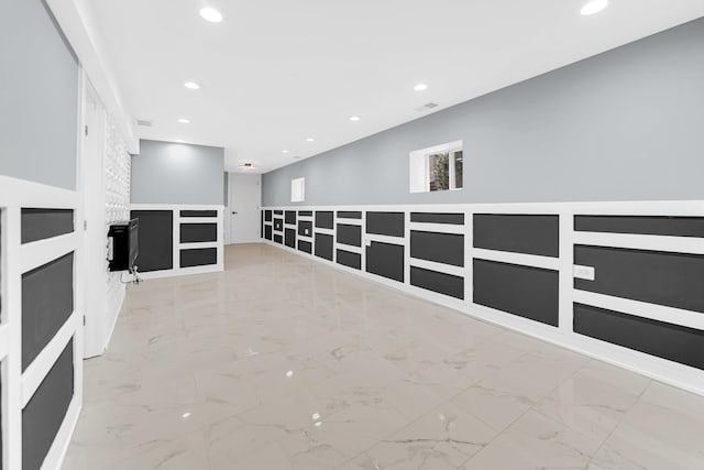 empty room with marble finish floor, a fireplace, and recessed lighting