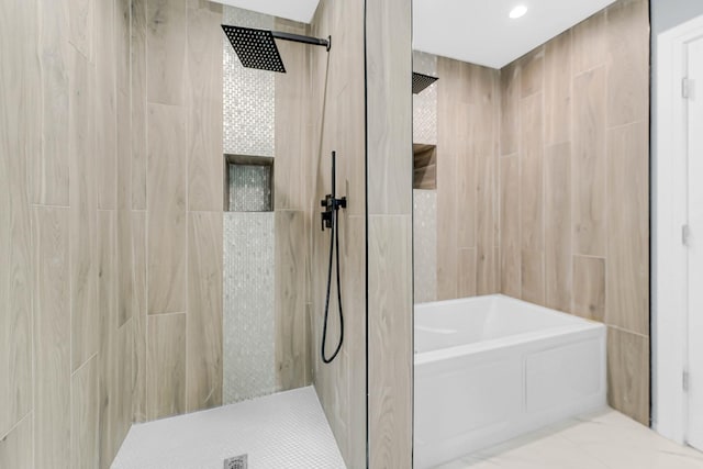 bathroom featuring a tile shower and a tub