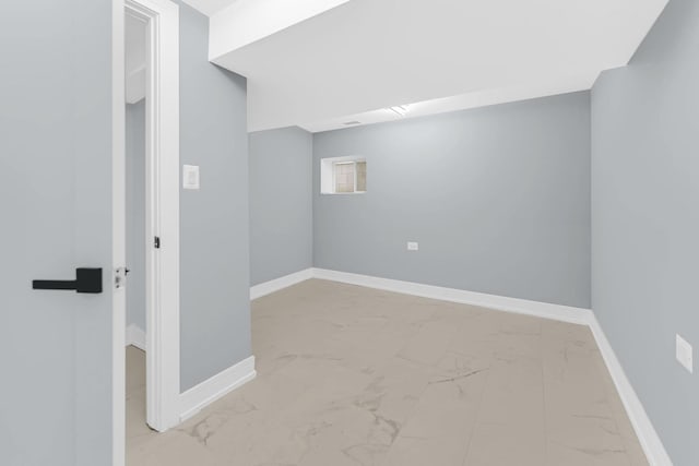 basement featuring baseboards and marble finish floor