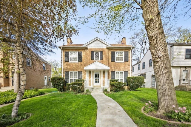 8436 Kedvale Ave, Skokie, IL 60076 - view of front of house with a chimney, a front yard, and brick siding