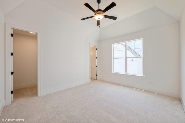 spare room featuring carpet flooring, a ceiling fan, baseboards, and lofted ceiling