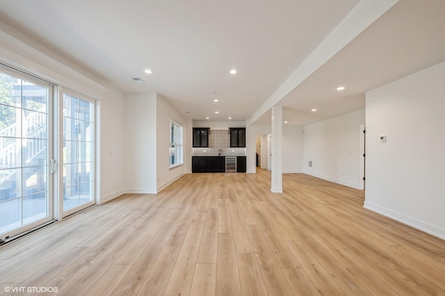 unfurnished living room with visible vents, light wood-style flooring, baseboards, and recessed lighting