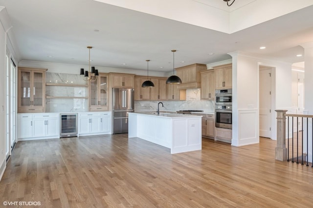 kitchen featuring beverage cooler, a sink, light countertops, tasteful backsplash, and appliances with stainless steel finishes