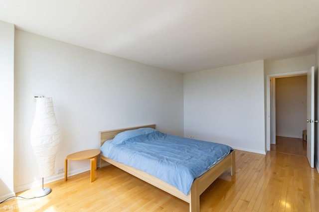 bedroom with light wood-style flooring and baseboards