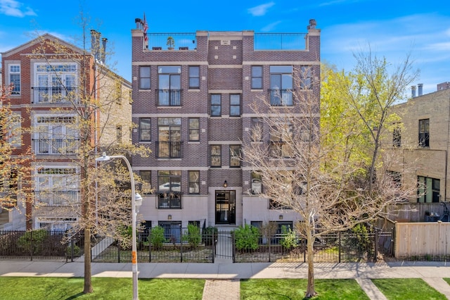 view of apartment building / complex featuring a fenced front yard