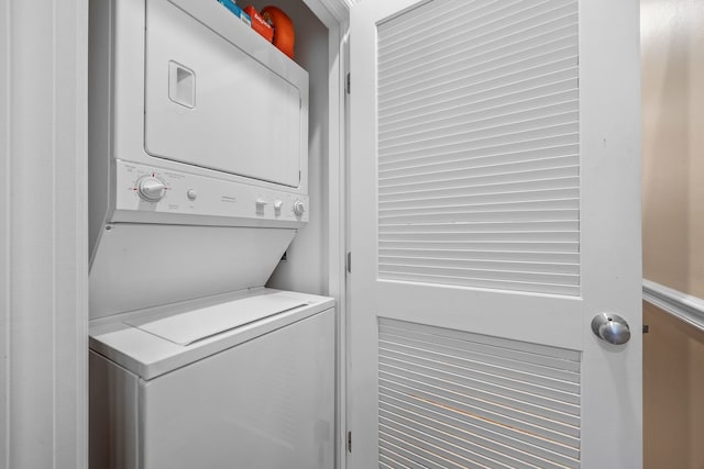 clothes washing area with estacked washer and dryer