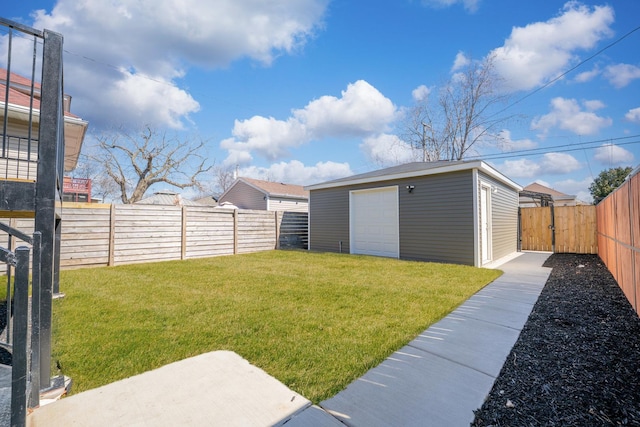 view of yard with an outdoor structure, a garage, and a fenced backyard