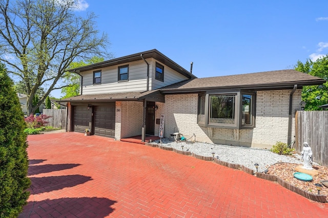 200 Marshall Dr, Des Plaines, IL 60016 - tri-level home with fence, brick siding, an attached garage, and driveway