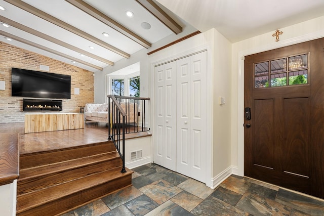 200 Marshall Dr, Des Plaines, IL 60016 - entrance foyer with baseboards, stone tile floors, brick wall, recessed lighting, and a lit fireplace