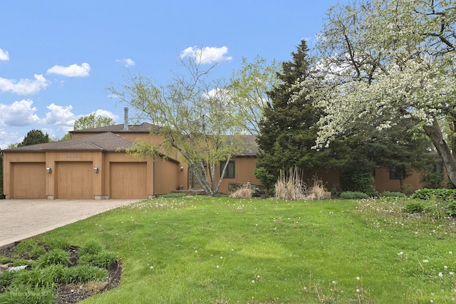 view of front of home featuring a front yard, driveway, a garage, and roof with shingles