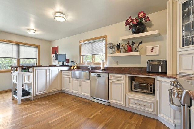 kitchen with appliances with stainless steel finishes, open shelves, a peninsula, and a kitchen breakfast bar