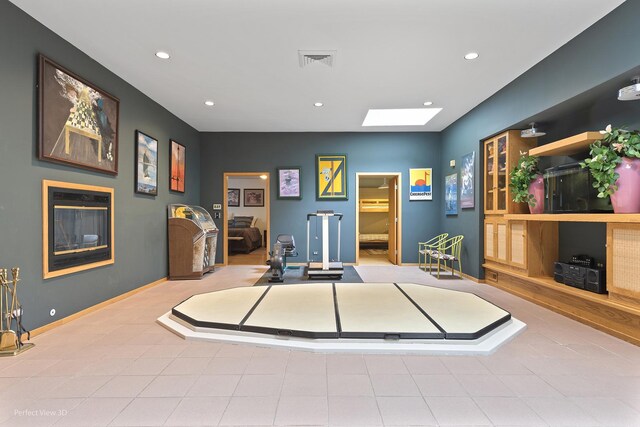 workout room with a skylight, recessed lighting, and baseboards