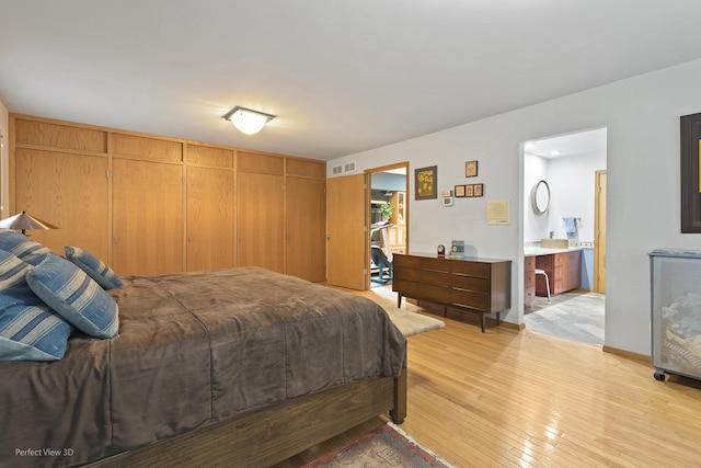 bedroom with light wood finished floors and ensuite bath
