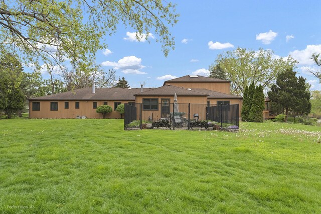 rear view of property featuring a lawn