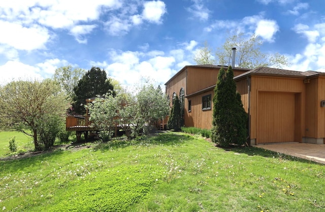 view of green lawn with a garage