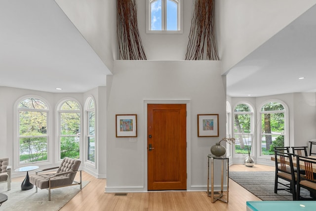 foyer featuring light wood-style flooring, baseboards, and recessed lighting