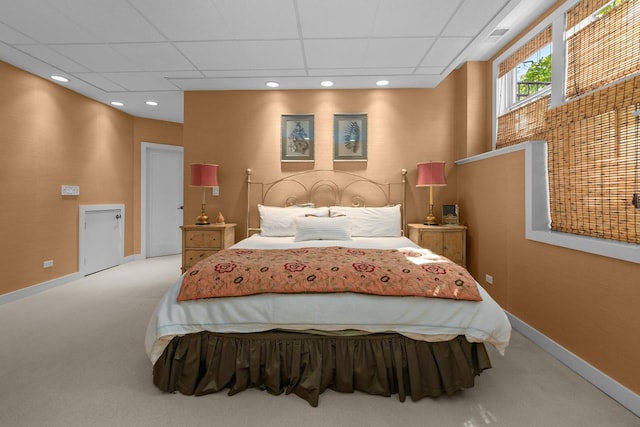 bedroom with carpet, a drop ceiling, and baseboards