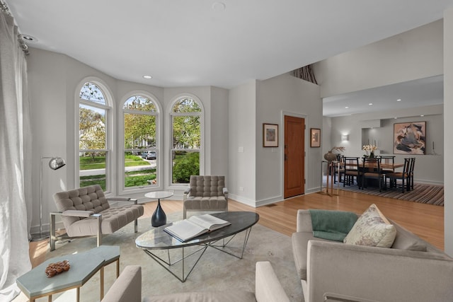 living room with light wood finished floors, baseboards, and recessed lighting