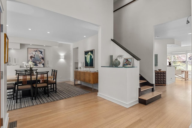 dining space featuring wood finished floors, stairs, baseboards, and recessed lighting