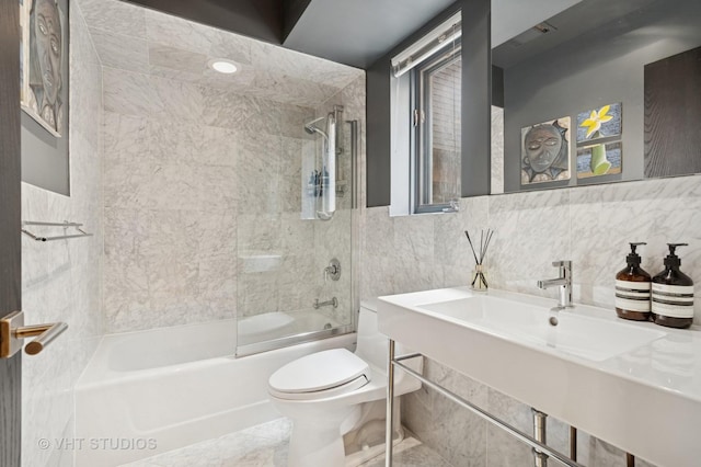 full bathroom with toilet, tile walls, bathtub / shower combination, and a sink