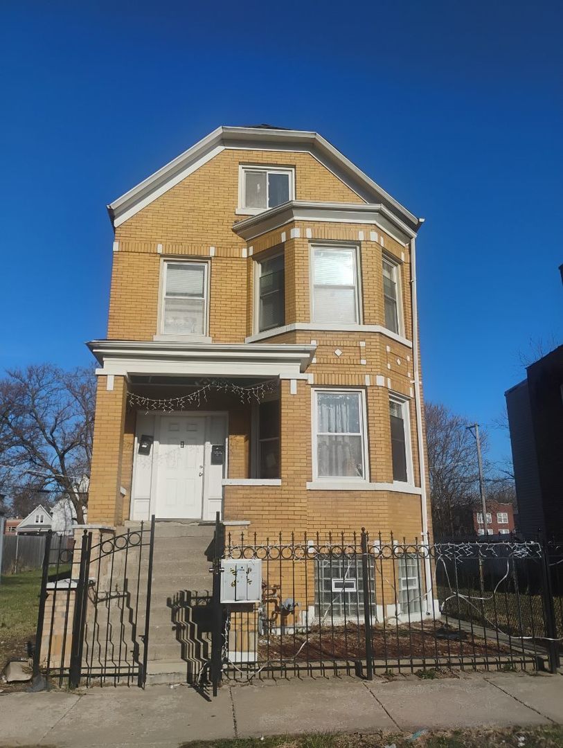 view of front of house with a fenced front yard and brick siding