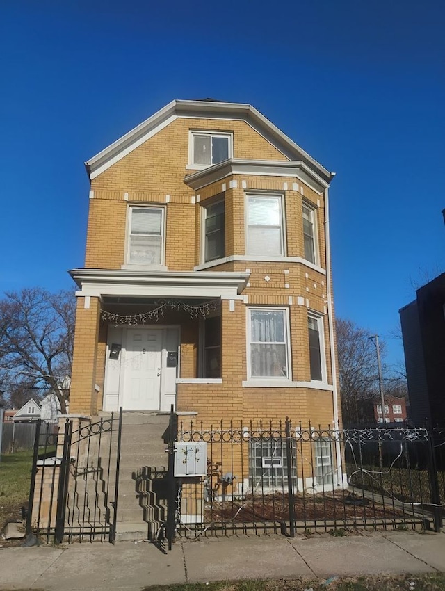 view of front of house with a fenced front yard and brick siding