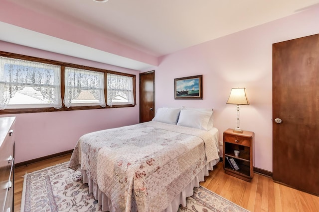 bedroom featuring light wood-style floors and baseboards