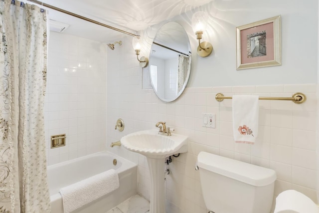 bathroom featuring toilet, shower / tub combo with curtain, and tile walls
