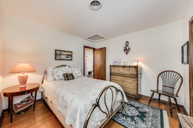 bedroom with attic access, wood finished floors, and baseboards